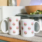 Two white mugs on a counter with baby's face multiplied around the mug in rows. Final product comes with images provided by customer. Shown in 15oz size with 4 rows of faces and 11oz size with 3 rows of faces.