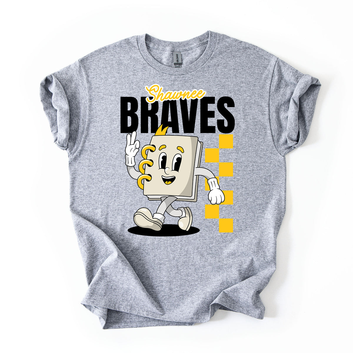 A heather gray short-sleeve t-shirt with a graphic print of a cartoon character notebook with yellow accents, the text 'Shawnee BRAVES' in black and yellow, and a yellow checkered pattern, shown on a plain white background.